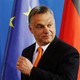 Hungarian Prime Minister Viktor Orbán stands in front of the European Union flag.