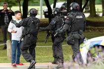 New Zealand police push back members of the public after the shooting at the Masjid Al Noor mosque in Christchurch.