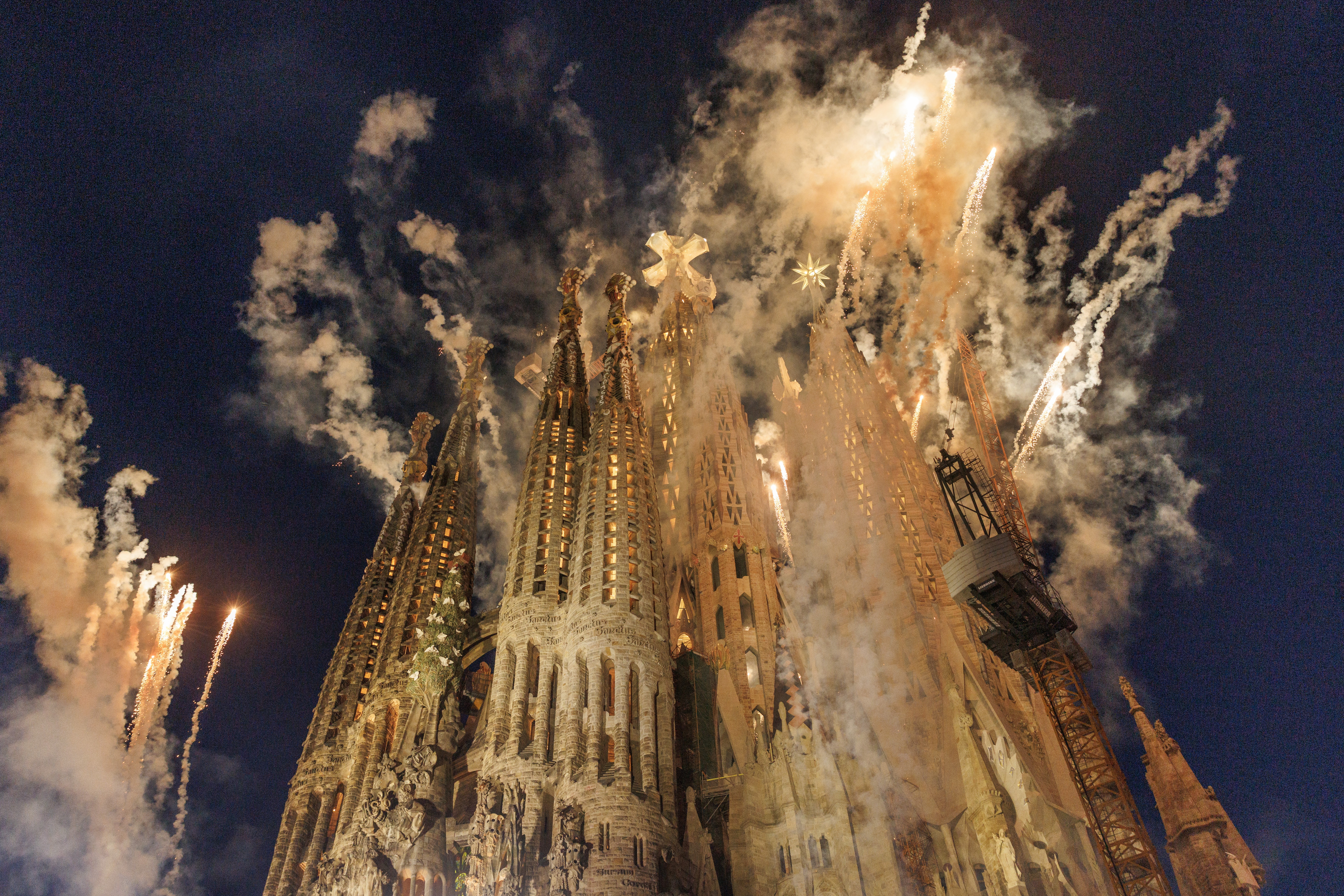 Smoke and fireworks erupt from the top of an ornate cathedral tower.