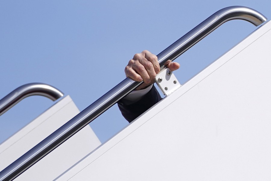 A hand is seen gripping a handrail.