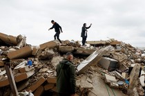 A mother and her son standing atop the rubble of a destroyed house in Tyre, Lebanon