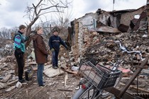 Residents stand outside a building on the outskirts of Chernihiv