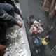 Syria Civil Defence members help an unconscious woman from a shelter in the besieged town of Douma, Eastern Ghouta, Damascus, on February 22, 2018. 