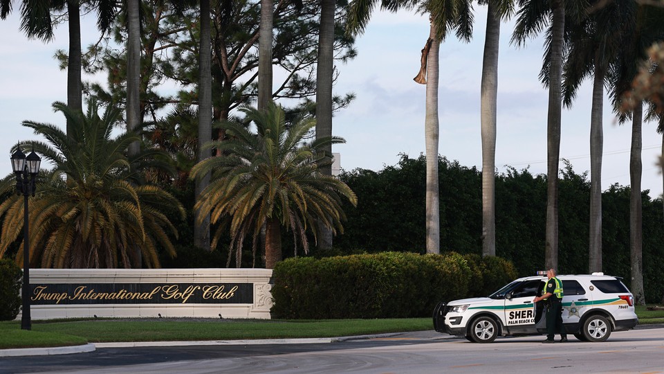 A sheriff's deputy stands outside Trump International Golf Club