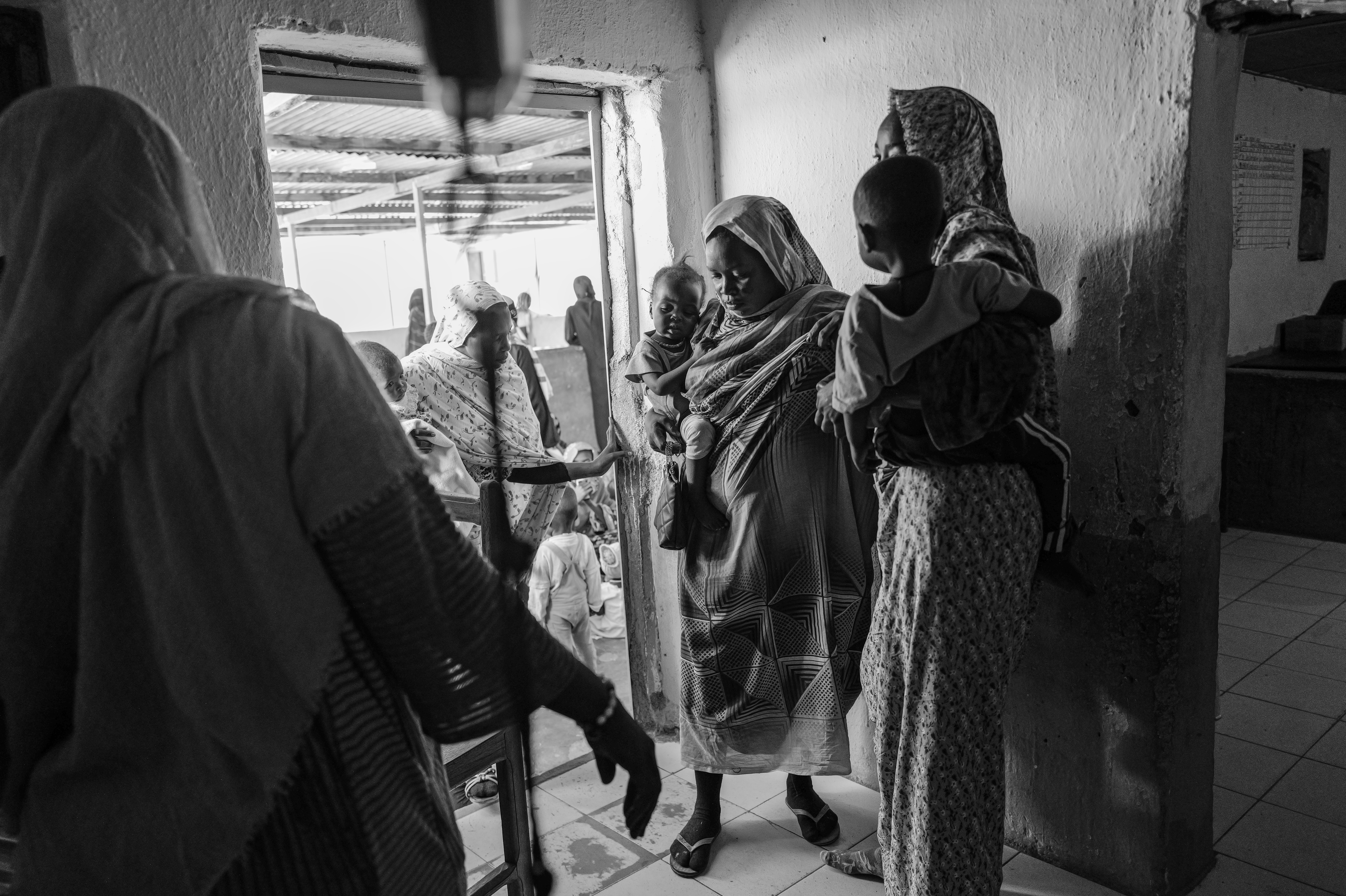 Picture of Sudanese women and their malnourished children wait to receive therapeutic food at the clinic in the Iridimi camp