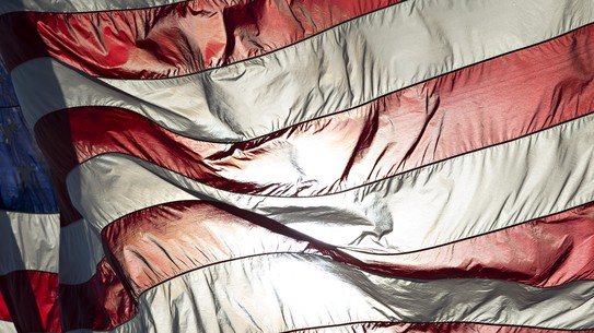 An American flag backlit with sunlight