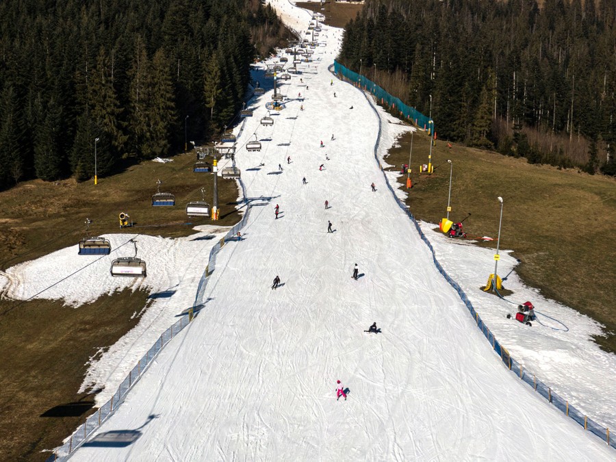 An aerial view of a ski slope operating with a dwindling amount of snow