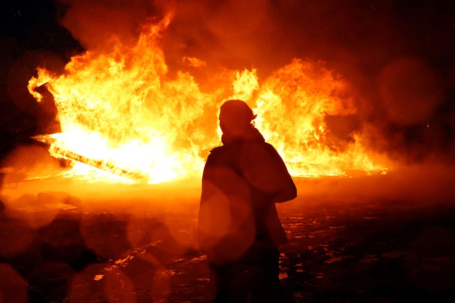 Chanse Zavalla, 26, from California, watches a building burn after it was set alight by protesters preparing to evacuate the main opposition camp near Cannon Ball, North Dakota, on February 22, 2017.