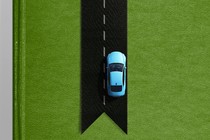 A car driving on a bookmark made to look like a road