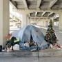 photograph of tent and Christmas tree under an overpass