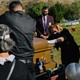 A woman mourns over a casket at a funeral of a victim of COVID-19.
