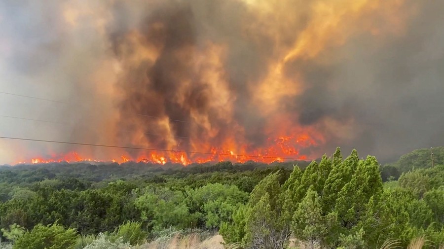 Flames and smoke rise from a brush fire.