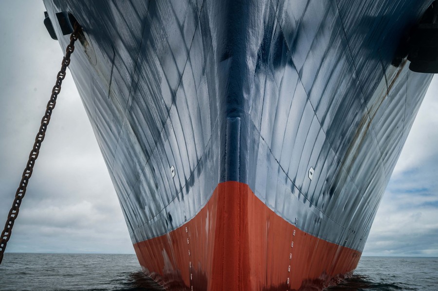 A close view of the hull of a ship at anchor.