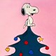 A still from A Charlie Brown Christmas showing Snoopy on top of a Christmas Tree as other characters dance below