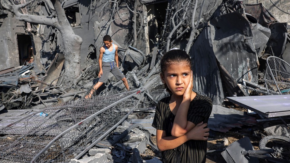 A girl stands amid rubble outside a bombed-out building in Rafah.