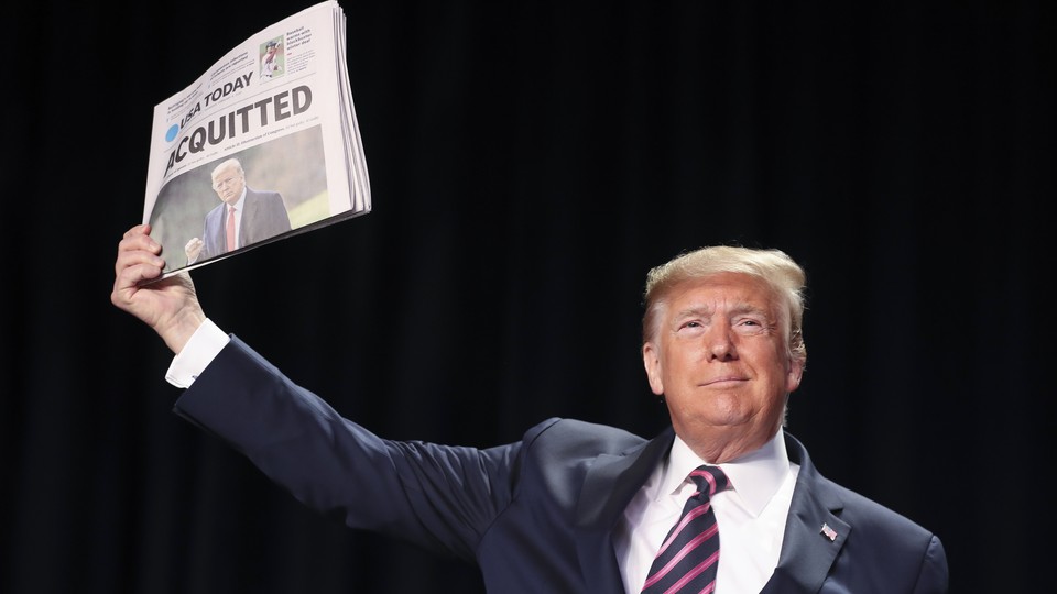 Trump displays a newspaper reading, "Acquitted"