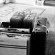 A black and white photograph of suitcases sitting by an entryway
