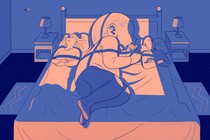 A giant baby sleeps between a husband and wife.