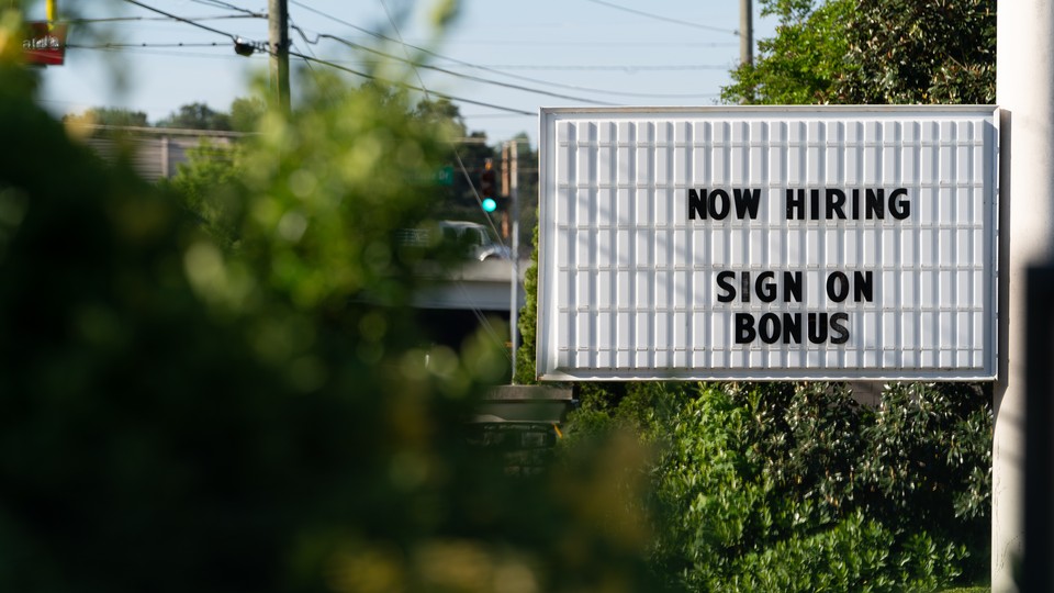 A sign that says "Now hiring" and "Sign on bonus."