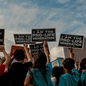 Anti-abortion protesters hold up signs