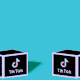 Two nurses pop out of jack-in-the-box-style cubes with the TikTok logo.