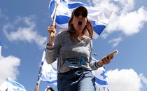 Low angle shot picture of woman holding Israeli flag and screaming.