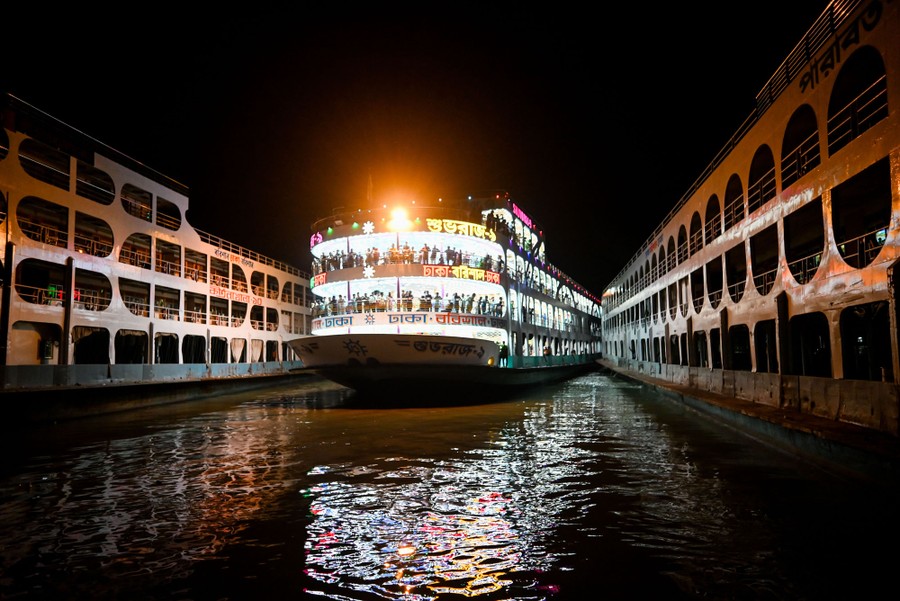 People stand on the decks of a ferry as it comes in to dock.