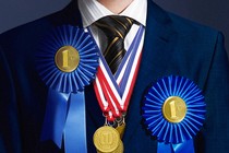 A boy in a formal school uniform with many ribbons and medals