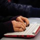 A person types on a laptop's keyboard.