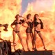 Three Victoria’s Secret models posing in front of an explosion of fire