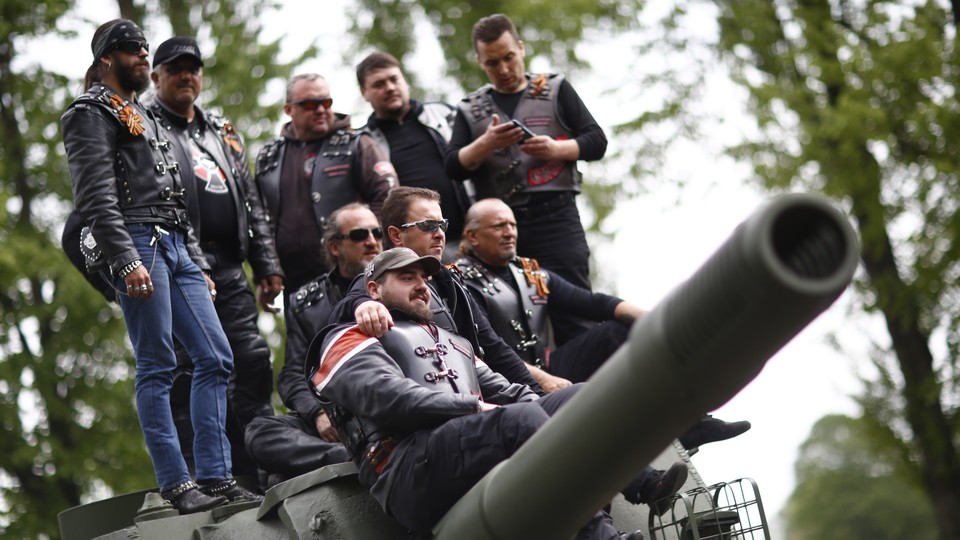 Members of the Night Wolves motorcycle group pose on top of a Red Army tank.