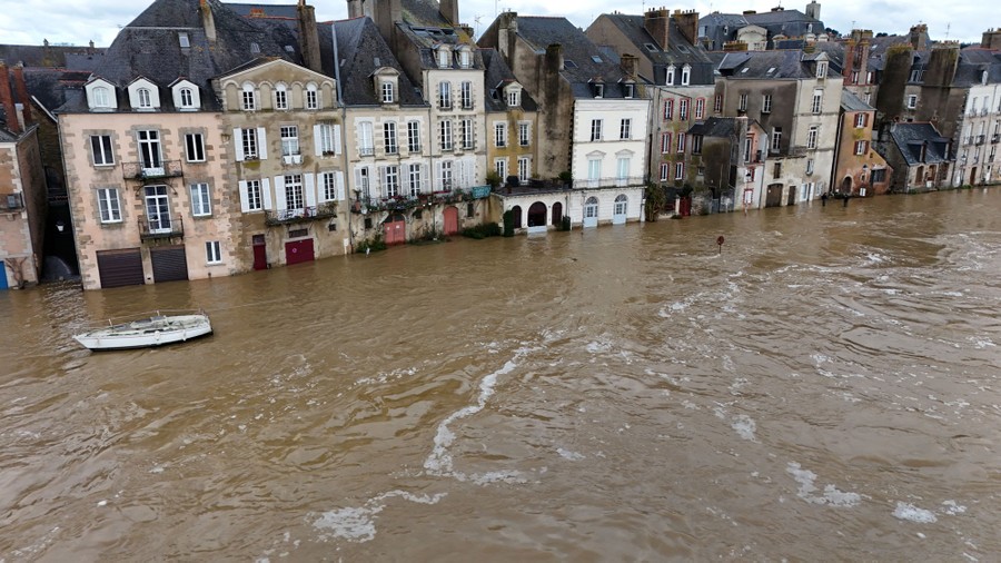 An aerial view of older European buildings standing in floodwater