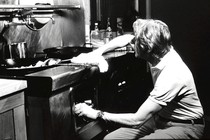 A black-and-white photo of a man cleaning a kitchen