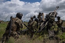 Ukrainian service members prepare to fire at Russian positions.