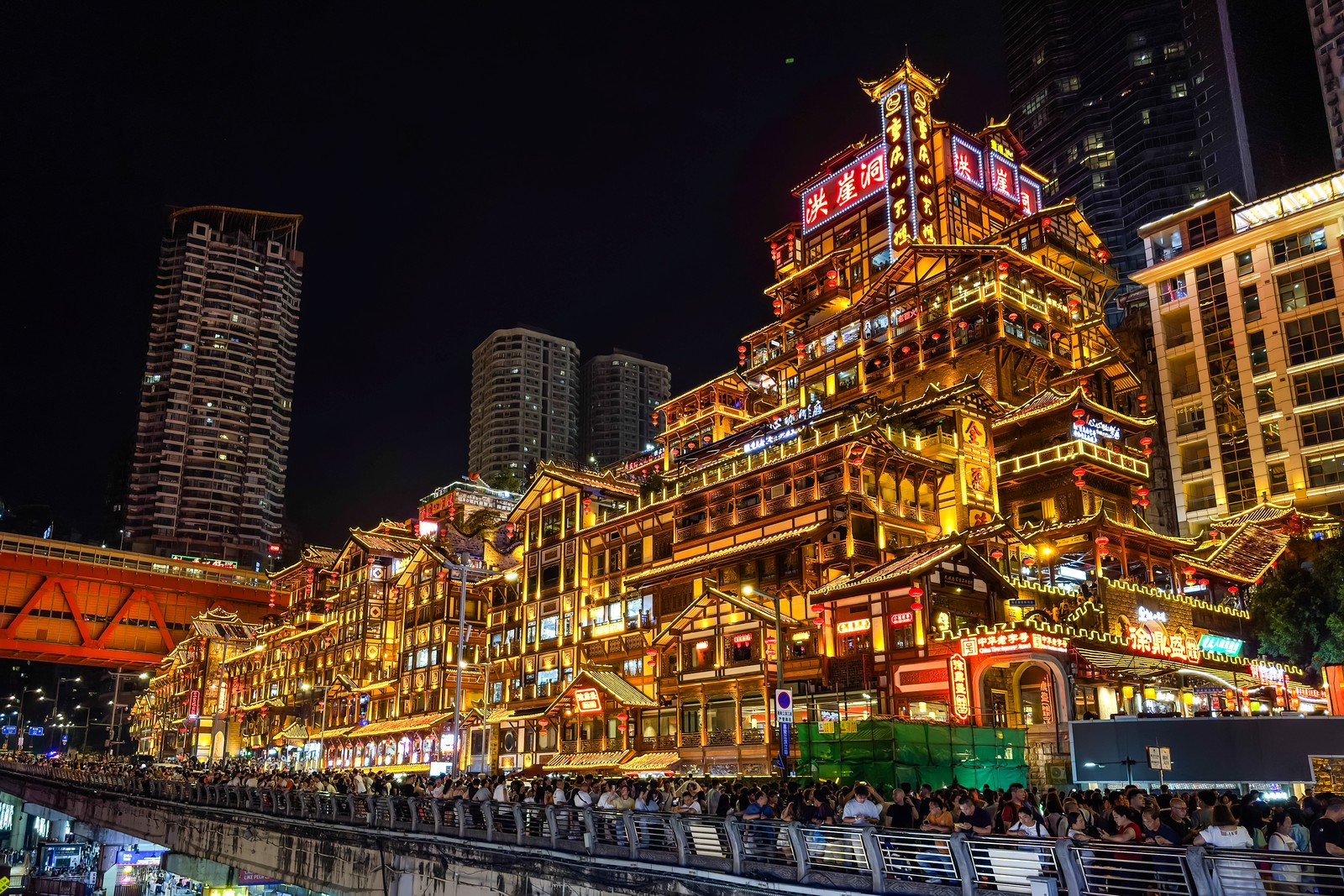 A complex historic structure in Chonqing, brightly illuminated, seen at night.