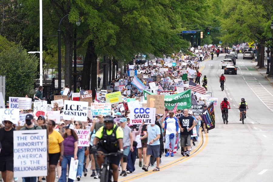 A long line of protesters marches down a street in Atlanta.