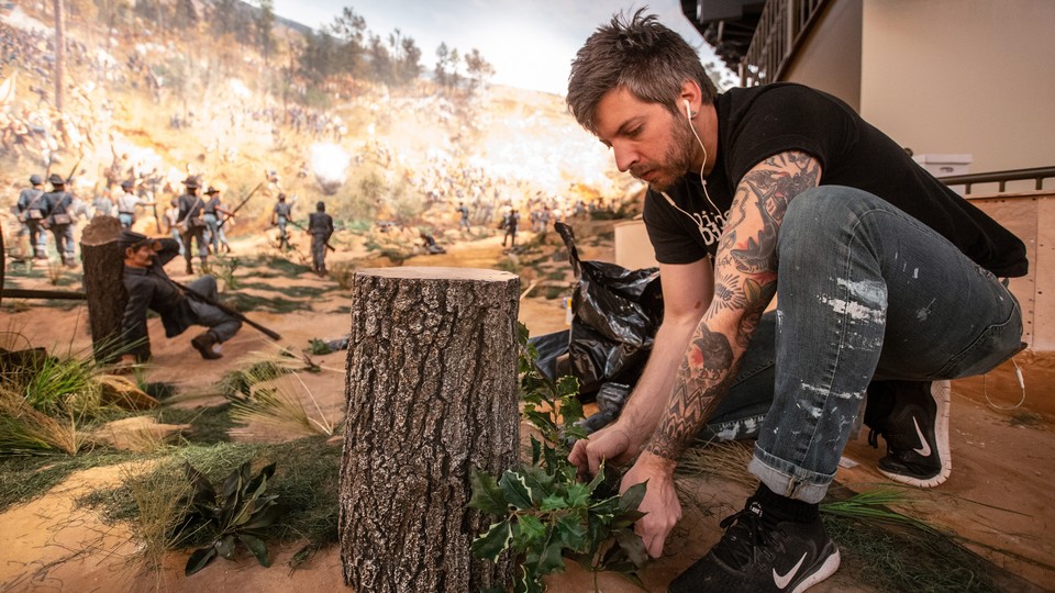 A worker puts some final touches on the diorama that is part of the Atlanta Cyclorama display.