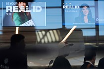 A news photo from an airport showing Real ID signs for travelers