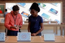 An Apple Store employee assists a customer.