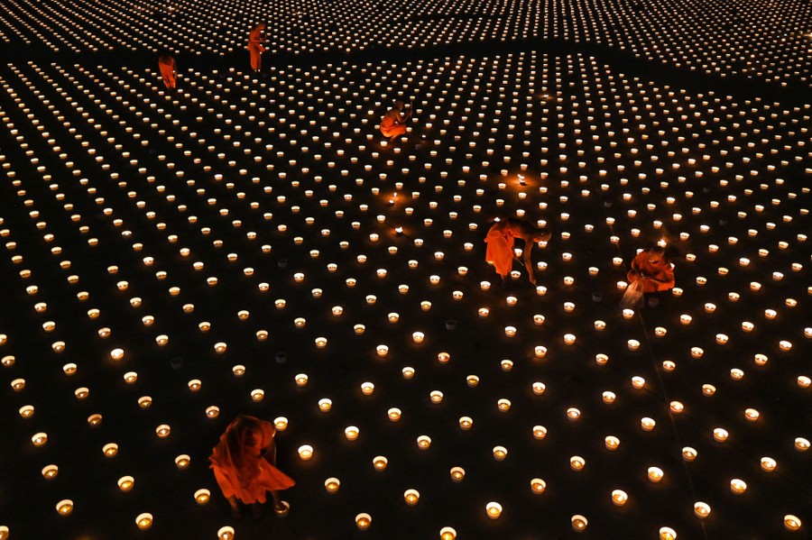 Monks light thousands of candles arranged in a large pattern.