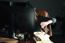 A woman eating in front of a computer