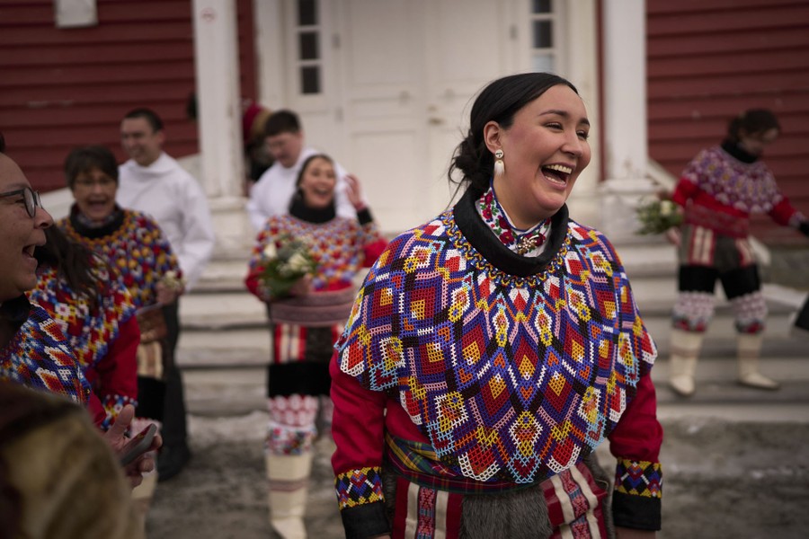 A woman laughs as others around her celebrate after a wedding.