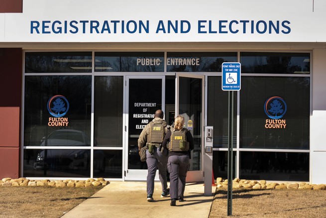 photo of public entrance of county building with two agents in FBI vests entering