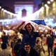 People celebrate on the Champs-Élysées, with the Arc de Triomphe in the background, after the semifinal match between France and Belgium at the 2018 World Cup