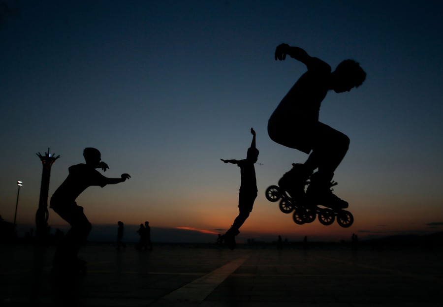 People roller skate at sunset.