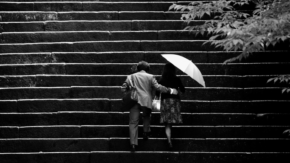 A black-and-white photo of a couple walking up some steps