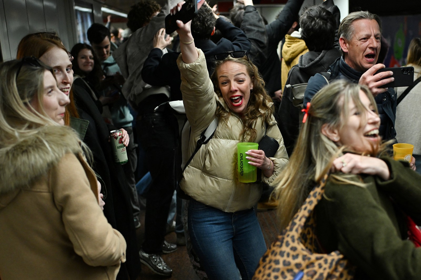 People celebrate in a metro station.