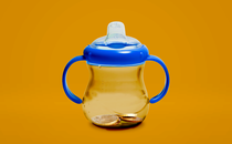 A baby's cup with coins inside