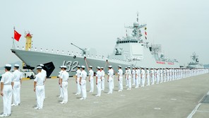 Members of the Chinese Navy stand on the deck of a naval destroyer.