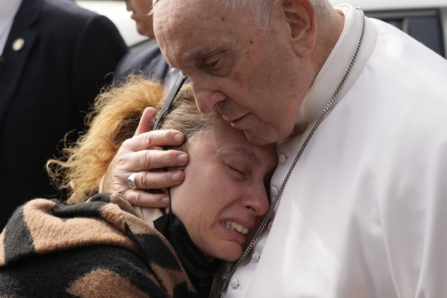 Pope Francis hugs a a woman who crying on his chest.